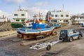 Fishermen prepare the old wooden fishing boat for the next turn in Famara