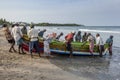 Fishermen pull a boat onto Uppuveli beach in Sri Lanka. Royalty Free Stock Photo