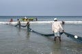 Fishermen pulling in nets on Uppuveli beach in Sri Lanka. Royalty Free Stock Photo