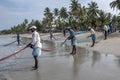 Fishermen pulling in nets on Uppuveli beach in Sri Lanka. Royalty Free Stock Photo