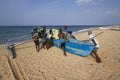 Fishermen pushing dugout canoe in Batticaloa, Sri Lanka