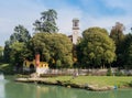 Fishermen relax next to a churchtower in Cassano d`Adda, Italy