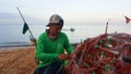 Fishermen remove fish and crabs from fishing nets at Jomtien beach Pattaya, Thailand