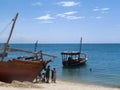 Fishermen on a sandy beach prepare their wooden boat boat for swimming and fishing Royalty Free Stock Photo