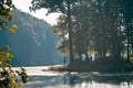 Fishermen silhouettes on a bank of little natural lake in forest, foggy morning beautiful summer sunrise, backlight nature Royalty Free Stock Photo