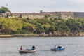 HAVANA,CUBA - JANUARY 11, 2021: Fishermen sitting in boats anchored at the entrance to the port of Havana, Cuba Royalty Free Stock Photo