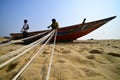 Fishermen weaving fishing net using nylon threads on Chandrabhaga beach, Konark, India.