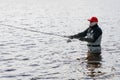 Fishermen spin fishing using chest waders