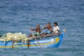 Fishermen of Sri Lanka in traditional boat, at Batticaloa