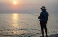 Fishermen stand fishing in the evening at a local fishing boat pier called Saphan Pla at Ban Na Kluea, Bang Lamung District