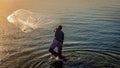 A fishermen throwing fishing net during sunrise in Al Khobar seaside Saudi Arabia Royalty Free Stock Photo