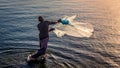 A fishermen throwing fishing net during sunrise in Al Khobar seaside Saudi Arabia Royalty Free Stock Photo