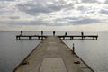 Fishermen waiting on a pier on a winter day. Cloudy sky and calm sea. Royalty Free Stock Photo