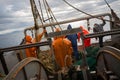 Fishermen in waterproof suits on the deck of fishing seiner