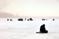 Fishermen on winter fishing with tents catch fish on the ice. Concept of male hobby, sport, passion, weekend in nature Royalty Free Stock Photo
