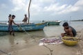 Fishermen and women collecting shellfish from their nets on the west coast beach on Delft Island in Sri Lanka.