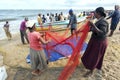 Fishermen and women sort fish from their nets on the beach at Negombo in Sri Lanka.