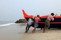 Fishermen work hard to bring the fishing boat to the shore