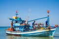 Phu Quoc, Vietnam, December 24, 2019: Three vietnamese fishermen on a wooden boat