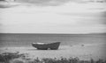 Fishermens boat at seacoast, on sand on cloudy day with sea on background. Fishing boat on beach in evening. Travel and Royalty Free Stock Photo