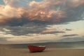 Fishermens boat at seacoast, on sand at sunset with horisont sea on background. Fishing boat on beach in evening. Travel