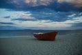 Fishermens boat at seacoast, on sand at sunset with horisont sea on background. Travel and rest concept. Background of Royalty Free Stock Photo