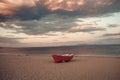 Fishermens boat at seacoast, on sand at sunset with horisont sea on background. Background of sea with waves and sky Royalty Free Stock Photo