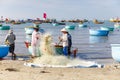 Fishers lay down fishing nets in a fishers harbor in Mui Ne, Vietnam