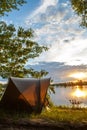 Fishing adventures, carp fishing. Angler, at sunset, is fishing with carpfishing technique. Camping on the shore of the lake.Carp