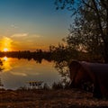 Fishing adventures, carp fishing. Angler, at sunset, is fishing with carpfishing technique. Camping on the shore of the lake.Carp