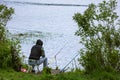 Fishing as a hobby. A man fishing with a fishing rod on the shore of a pond, river or lake, will spend his free time Royalty Free Stock Photo