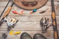 Fishing background theme. Fishing rods with reels, fishing tackles, rubber boots, fishing buoy and polarized glasses on greywooden Royalty Free Stock Photo