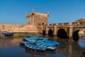 Fishing beautiful blue boats, gear and catch on background of Castelo Real of Mogador in Essaouira old harbor Royalty Free Stock Photo