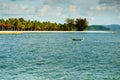 Fishing boat alone in the bay with blue water and forest