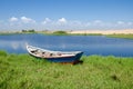 Fishing boat anchored in lagoon with green grass and dunes