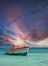 Fishing boat anchored in a peaceful bay in Aruba under dramatic sky Royalty Free Stock Photo