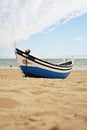 Fishing boat. Atlantic ocean beach. Portugal. Sand water waves and the sky clouds. Blue white. Europe. Travel. Royalty Free Stock Photo