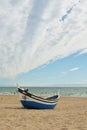 Fishing boat. Atlantic ocean beach. Portugal. Sand water waves and the sky clouds. Blue white. Europe. Travel. Royalty Free Stock Photo