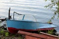 Fishing boat in a calm lake water/old wooden fishing boat/ wooden fishing boat in a still lake water Royalty Free Stock Photo