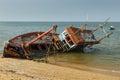 Fishing boat crashed lies on its side near the shore Royalty Free Stock Photo