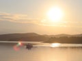 A fishing boat crosses the sea bay in the morning sun. Dawn at the resort. Heavy human labor. Calm and rest after sea crossing. Cr Royalty Free Stock Photo