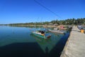 A Fishing Boat Docking with a Blue Sky and Reflections on the Water