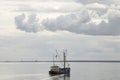 Fishing boat is emptying the nets, placed along the Aflsluitdijk in a calm peacfull IJsslemeer Royalty Free Stock Photo