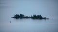 Fishing boat with fishermen on a big lake with a little island next to them. Royalty Free Stock Photo