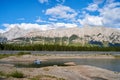 A fishing boat with fishermen fishing on a beautiful natural mountain lake on a sunny summer day with rocky mountains in the Royalty Free Stock Photo