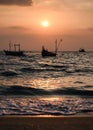 Fishing boat floating on tropical sea beach at sunset Royalty Free Stock Photo