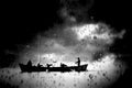 Fishing boat going fishing, silhouettes among raindrops