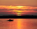 A fishing boat on a lake in sunset scene