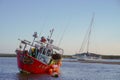 Red fishing boat moored at low water.