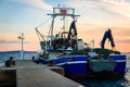 Fishing boat moored or docked at pier in sunset Royalty Free Stock Photo